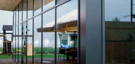 Elegant wooden home terrace with balcony. doors from bathroom and bedroom. Panorama of spacious terrace with wooden floor and furniture and amazing view.