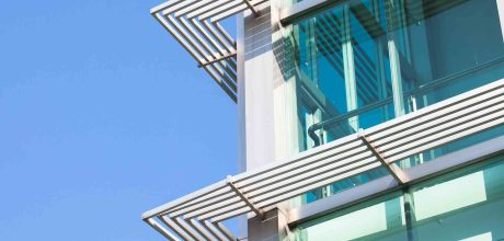 Close-up of glass building with windows reflected to the sky